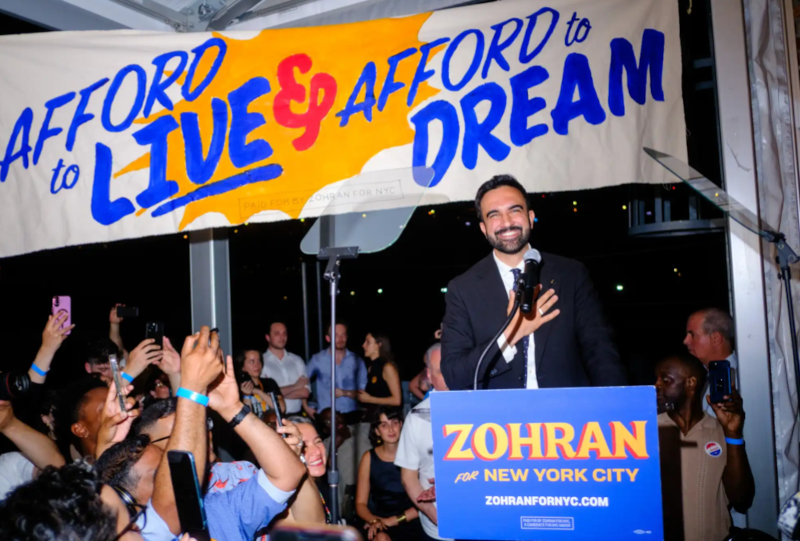 Image of Zohran Mamdani with his hand over his heart, smiling, as he finally took the stage after midnight for his victory speech 